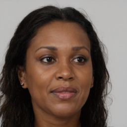 Joyful black adult female with long  brown hair and brown eyes