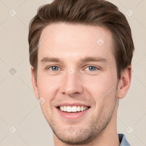 Joyful white young-adult male with short  brown hair and grey eyes