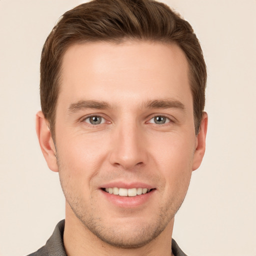 Joyful white young-adult male with short  brown hair and grey eyes