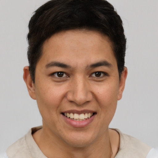Joyful latino young-adult male with short  brown hair and brown eyes