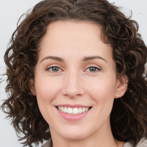 Joyful white young-adult female with medium  brown hair and green eyes