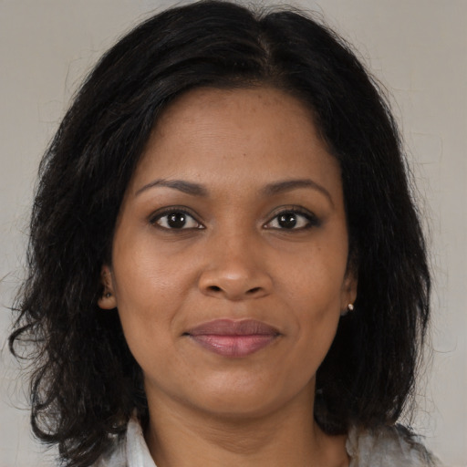 Joyful black adult female with medium  brown hair and brown eyes