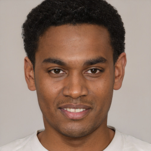Joyful black young-adult male with short  black hair and brown eyes