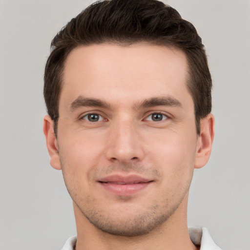 Joyful white young-adult male with short  brown hair and grey eyes