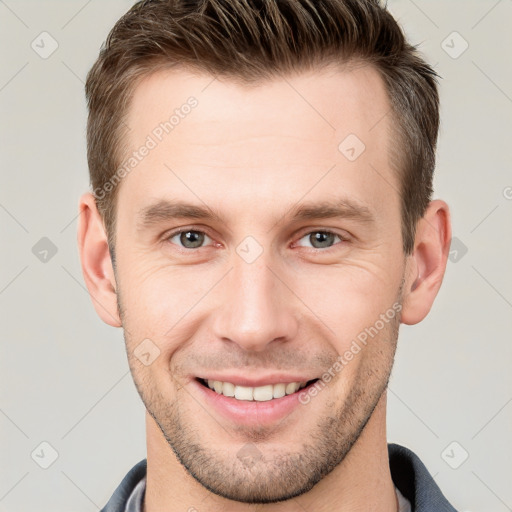 Joyful white young-adult male with short  brown hair and grey eyes