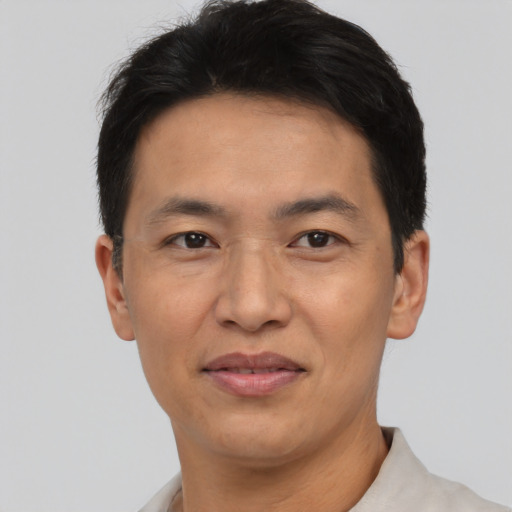 Joyful asian adult male with short  black hair and brown eyes