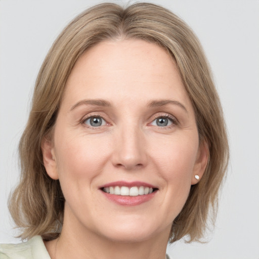 Joyful white adult female with medium  brown hair and blue eyes