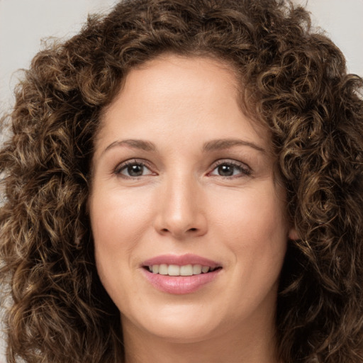 Joyful white young-adult female with long  brown hair and green eyes