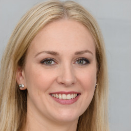 Joyful white young-adult female with long  brown hair and blue eyes