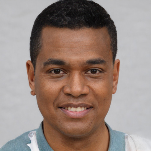 Joyful latino young-adult male with short  brown hair and brown eyes