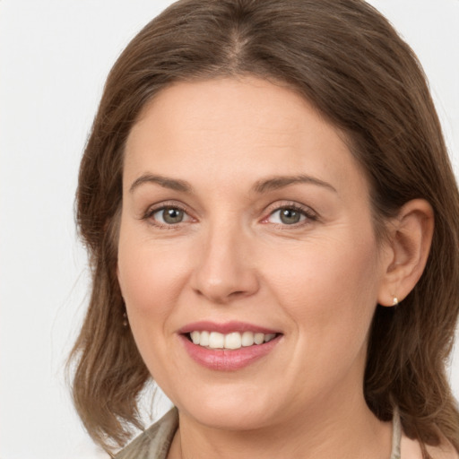 Joyful white young-adult female with medium  brown hair and grey eyes