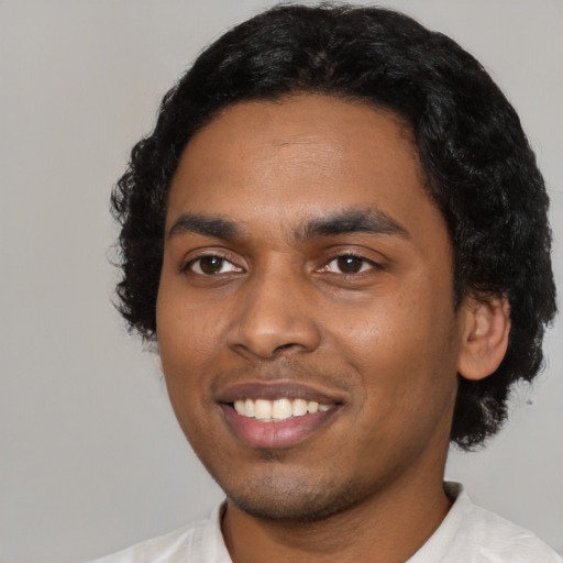 Joyful black young-adult male with short  black hair and brown eyes