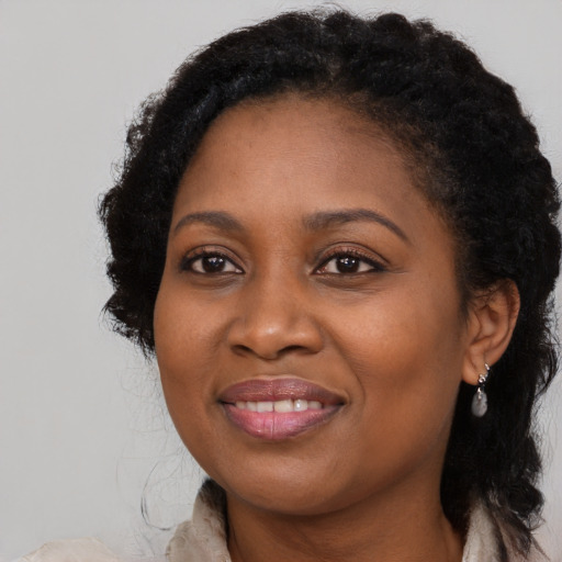 Joyful black adult female with long  brown hair and brown eyes