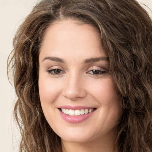 Joyful white young-adult female with long  brown hair and green eyes