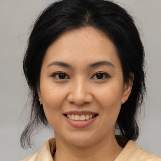 Joyful asian young-adult female with medium  brown hair and brown eyes