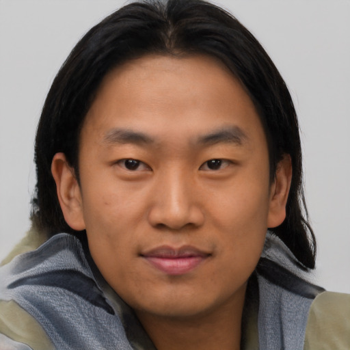 Joyful asian young-adult male with short  brown hair and brown eyes