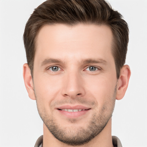 Joyful white young-adult male with short  brown hair and grey eyes