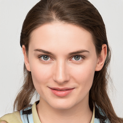 Joyful white young-adult female with medium  brown hair and grey eyes