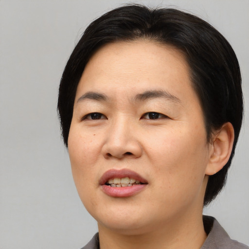 Joyful asian young-adult female with medium  black hair and brown eyes