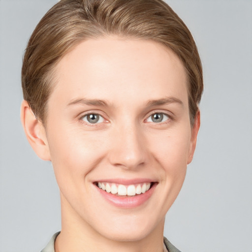 Joyful white young-adult female with short  brown hair and grey eyes