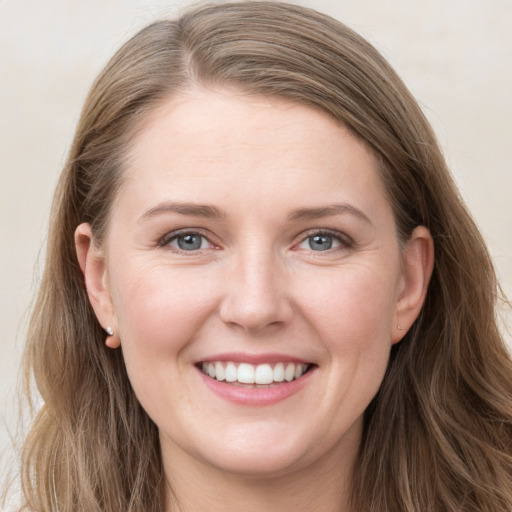 Joyful white young-adult female with long  brown hair and grey eyes