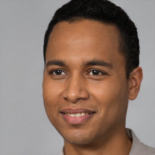 Joyful black young-adult male with short  black hair and brown eyes