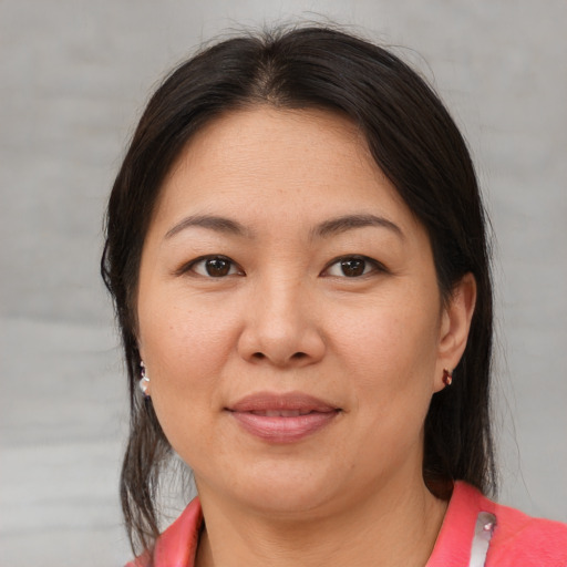 Joyful latino adult female with medium  brown hair and brown eyes