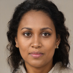 Joyful black young-adult female with long  brown hair and brown eyes