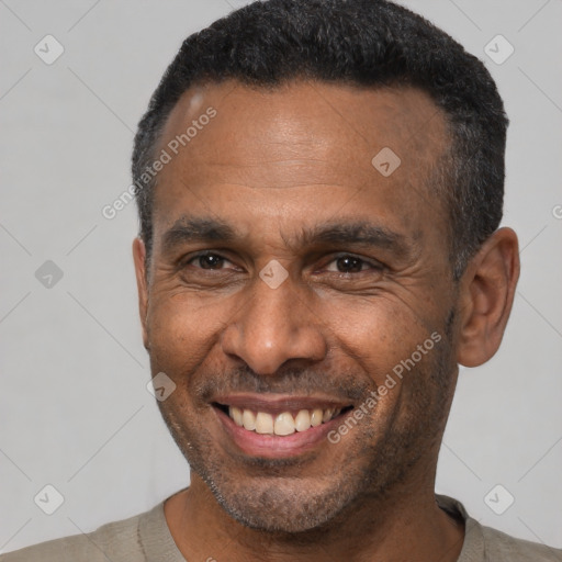 Joyful black adult male with short  black hair and brown eyes