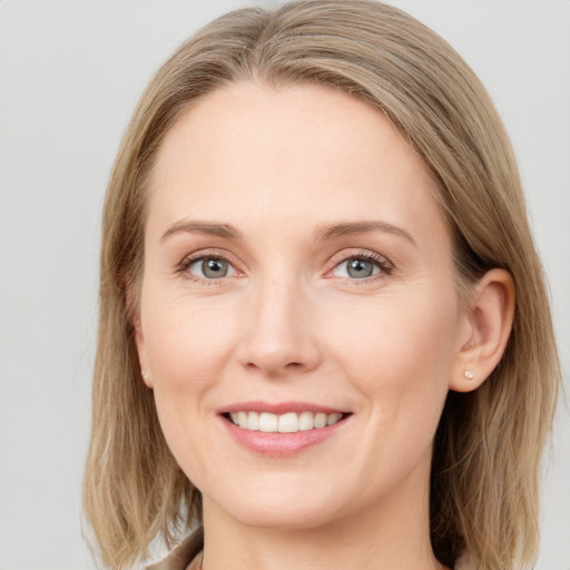 Joyful white young-adult female with long  brown hair and blue eyes