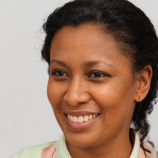 Joyful black young-adult female with long  brown hair and brown eyes