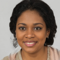 Joyful black young-adult female with long  brown hair and brown eyes