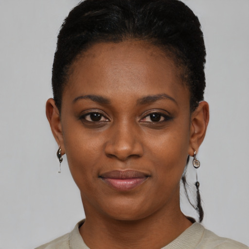 Joyful black young-adult female with short  black hair and brown eyes
