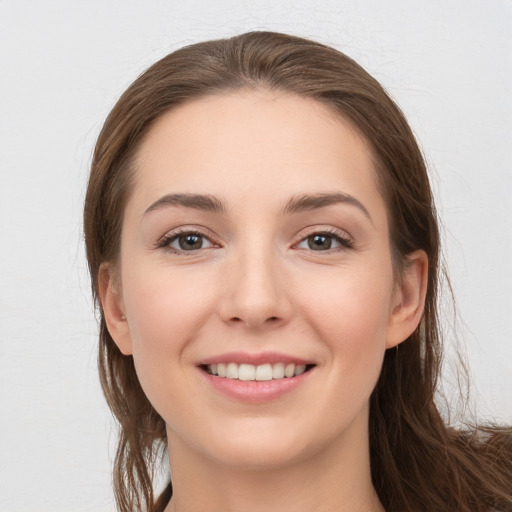 Joyful white young-adult female with long  brown hair and grey eyes