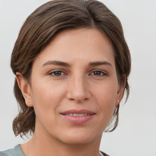 Joyful white young-adult female with medium  brown hair and grey eyes