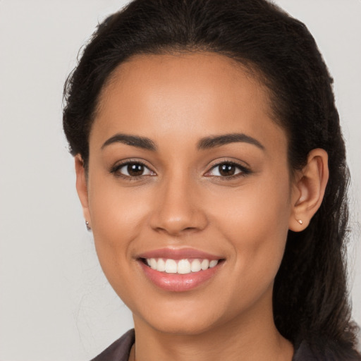 Joyful latino young-adult female with long  brown hair and brown eyes