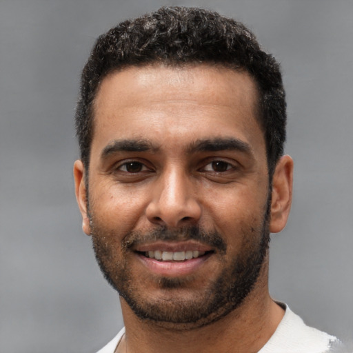 Joyful white young-adult male with short  black hair and brown eyes