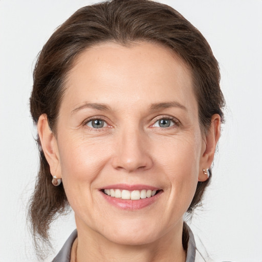 Joyful white adult female with medium  brown hair and grey eyes