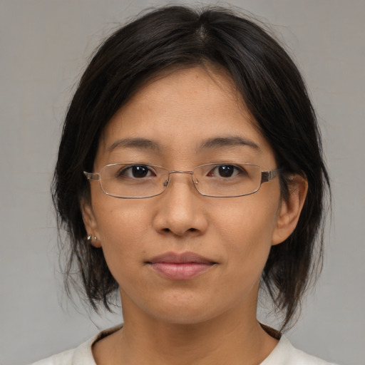 Joyful asian adult female with medium  brown hair and brown eyes