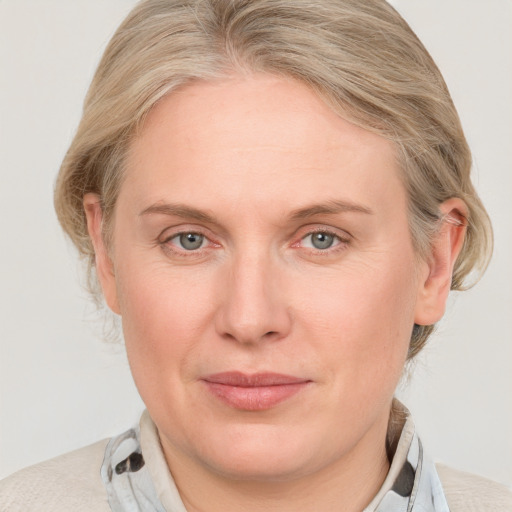 Joyful white adult female with medium  brown hair and blue eyes