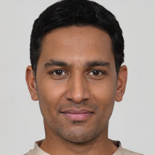 Joyful latino young-adult male with short  black hair and brown eyes