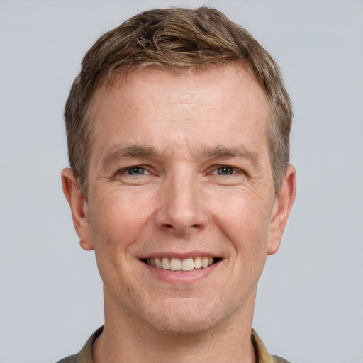 Joyful white adult male with short  brown hair and grey eyes