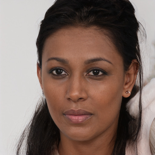Joyful black young-adult female with long  brown hair and brown eyes