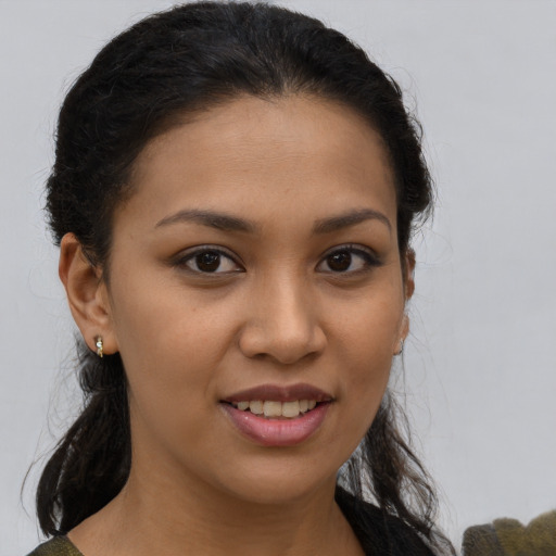 Joyful latino young-adult female with long  brown hair and brown eyes