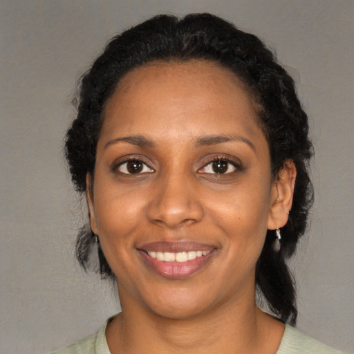 Joyful black young-adult female with medium  black hair and brown eyes
