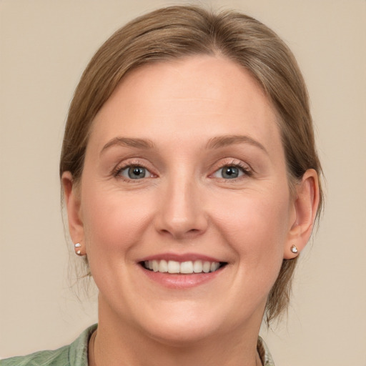 Joyful white adult female with medium  brown hair and blue eyes