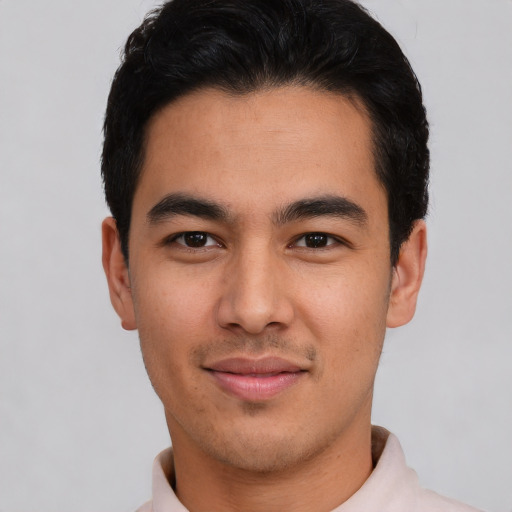 Joyful latino young-adult male with short  black hair and brown eyes
