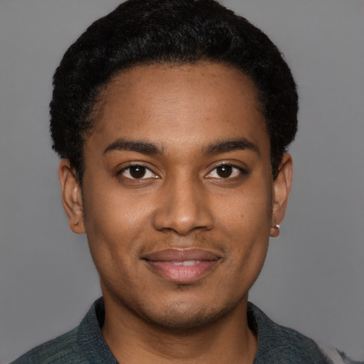 Joyful black young-adult male with short  black hair and brown eyes