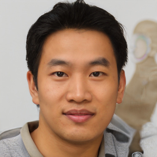 Joyful asian young-adult male with short  black hair and brown eyes