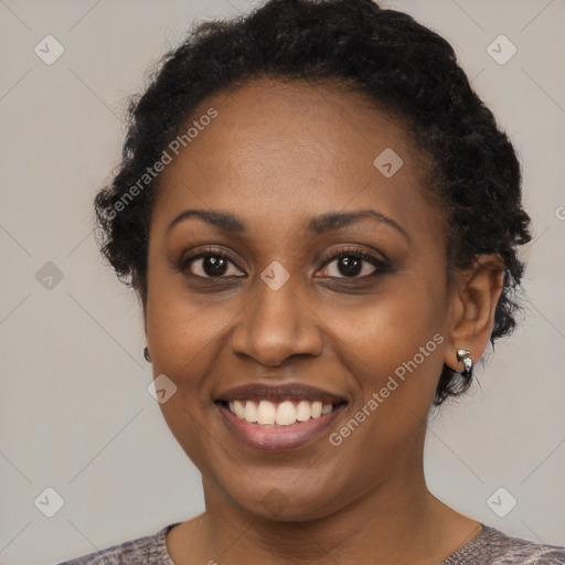 Joyful black young-adult female with short  black hair and brown eyes